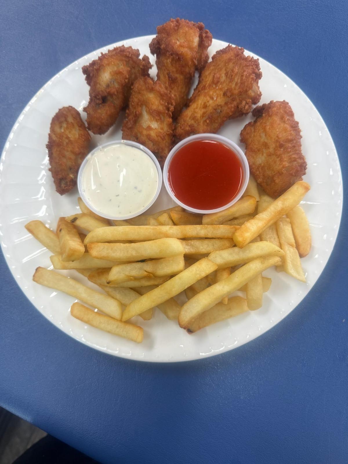 Alitas de pollo con papas fritas y salsas