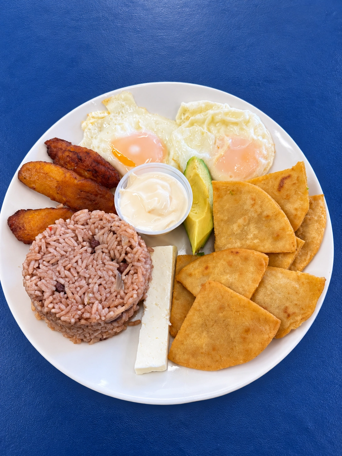 Desayuno Catracho con huevos, plátanos, arroz con frijoles, queso, aguacate y tortillas fritas