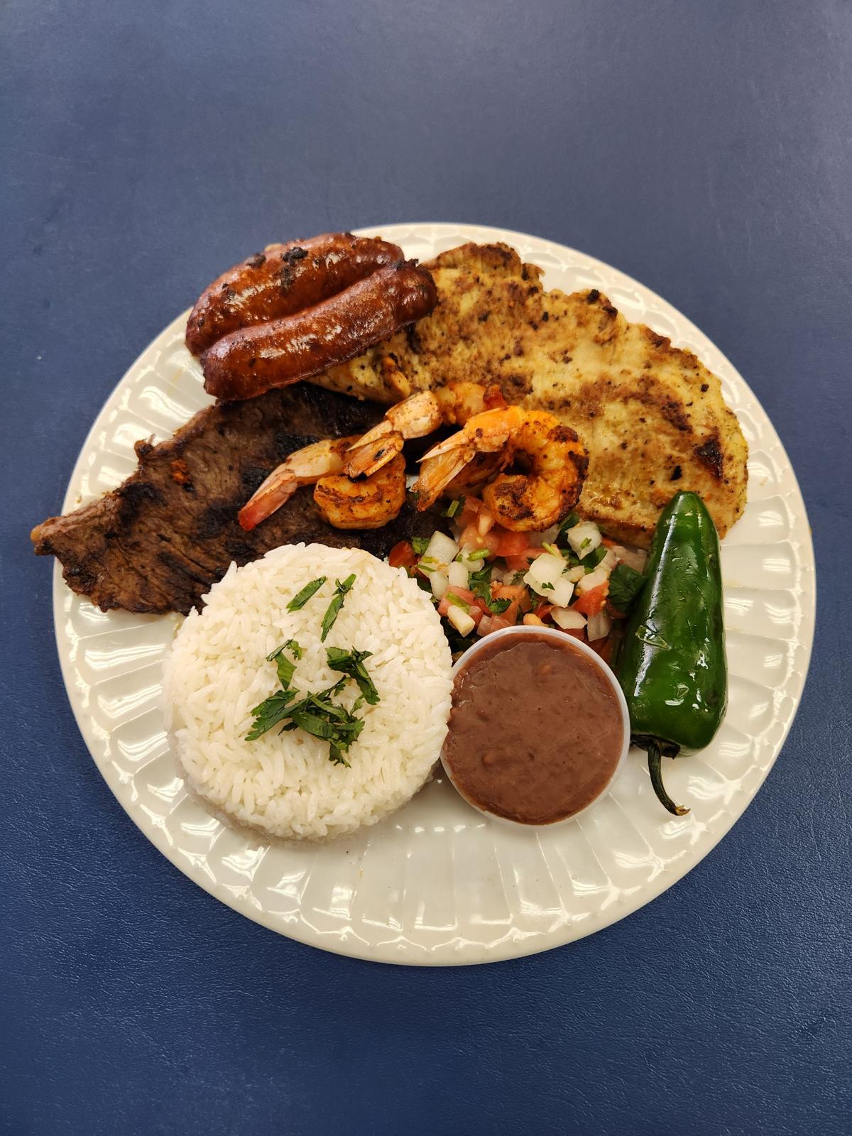 Plato Mar y Tierra con carne asada, pollo, camarones, chorizo, arroz, frijoles y pico de gallo